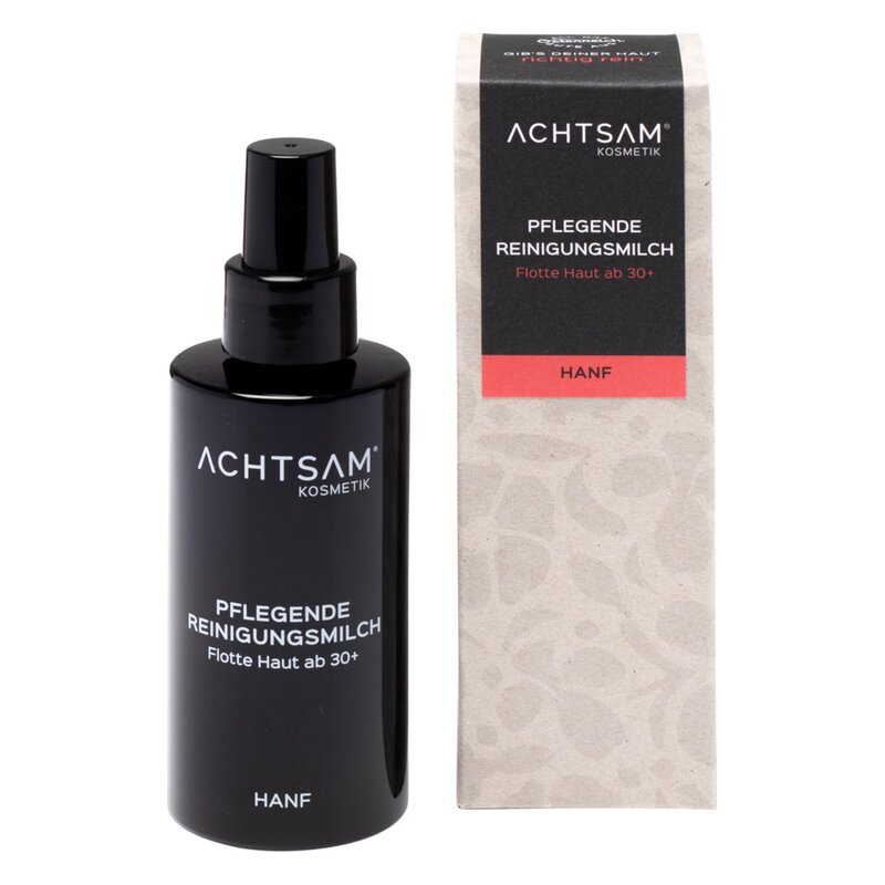 Schwarze Flasche mit Pumpspender für pflegende Reinigungsmilch, neben einer gefalteten, strukturierten Verpackung.