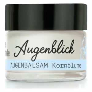 Eine Glasdose mit schwarzem Deckel für Augenbalsam, beschriftet mit "Augenblick" und "Augenbalsam Kornblume".