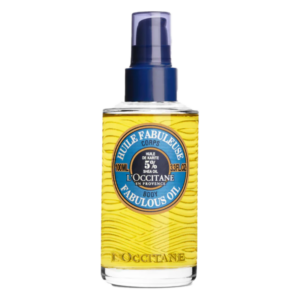 Transparente Flasche mit gelber Körperöl, Pumpe und blauem Verschluss, beschriftet mit "Huile Fabuleuse" und Marke.