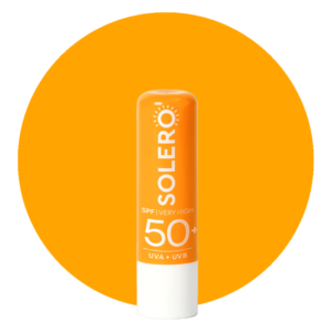 Sonnencreme-Stick der Marke Solero mit hohem Lichtschutzfaktor in orange, vor einem leuchtend orangefarbenen Hintergrund.