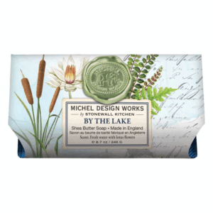 Verpackung eines Shea-Butter-Seifenstücks mit botanischem Design und einem Siegel, beschriftet "BY THE LAKE".