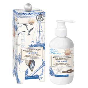 Hand- und Körperlotion in weißer Flasche neben einer verzierten Verpackung mit maritimen Motiven und Kunstwerken.