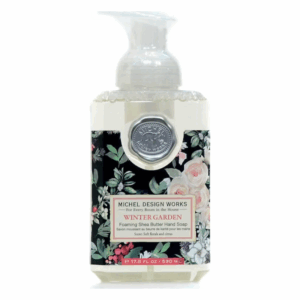 Flüssigseife in einer transparenten Spenderflasche mit Blütenmustern und silberner Münze auf dem Verschluss.