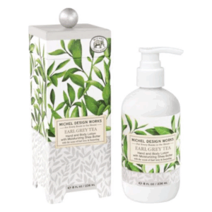 Eine Flasche Hand- und Körperlotion in einer dekorativen Verpackung mit Blättermuster und silberner Kappe, Duft: Earl Grey Tea.