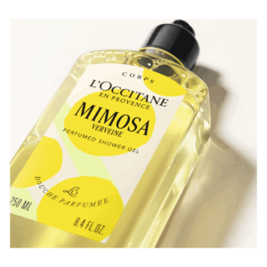 Flasche mit gelbem Duschgel von L'Occitane, Etikett mit Mimosenmotiven und schwarzem Verschluss.