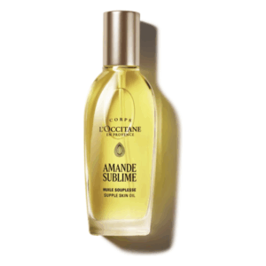 Glasflasche mit goldenem Hautöl von L'Occitane, etikettiert als "Amande Sublime" mit einem stilvollen Verschluss.