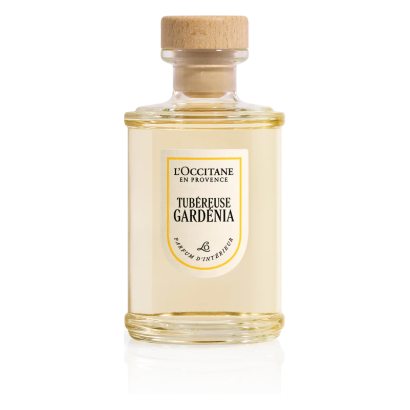 Ein transparenter Glasbehälter mit holzfarbenem Verschluss, gefüllt mit einem Duft namens Tubéreuse Gardenia von L'Occitane.