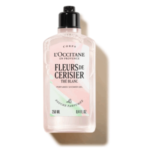 Flasche mit parfümiertem Duschgel von L'Occitane, blassrosa mit schwarzem Verschluss und dekorativem Etikett.