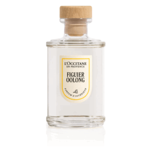Flasche mit Duft für den Innenraum, Holzverschluss, transparentes Design, Etikett mit 'FIGUIER OOLONG'.