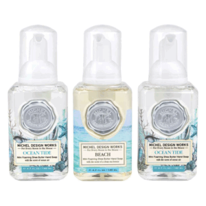 Drei Flaschen mit Mini schäumender Shea-Butter-Handseife, zwei Sorten: Ocean Tide und Beach, beide mit maritimen Designs.